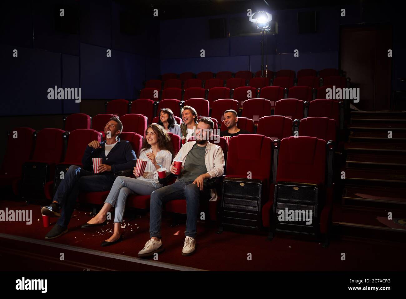 Weitwinkelansicht von Freunden, die Filme im Kino ansehen, während Sie in einem leeren Saal die private Wiedergabe genießen und Platz zum Kopieren nutzen Stockfoto