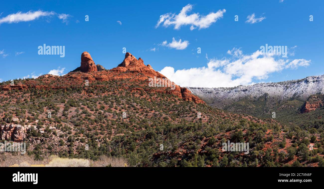 Thumb Butte und der Mond steigen nach einem Schneesturm Anfang März über Sedona auf. Stockfoto