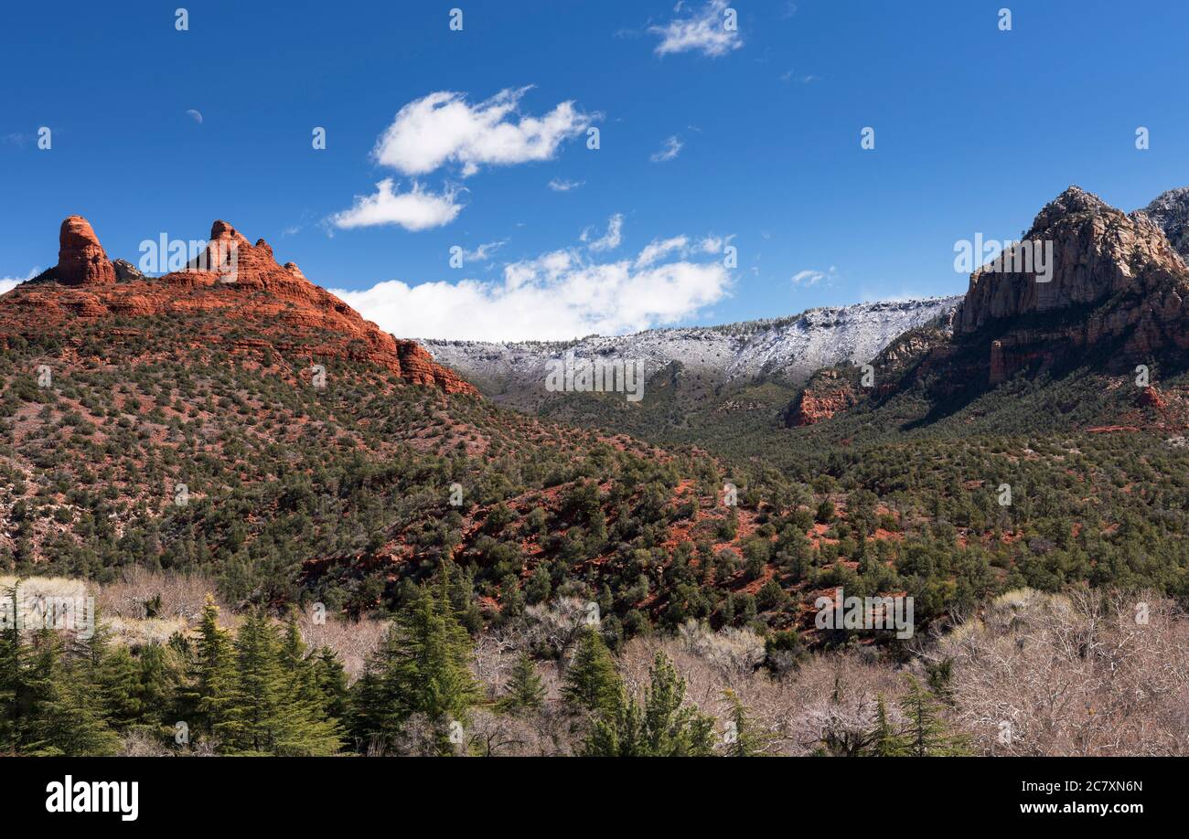 Thumb Butte und der Mond steigen nach einem Schneesturm Anfang März über Sedona auf. Stockfoto