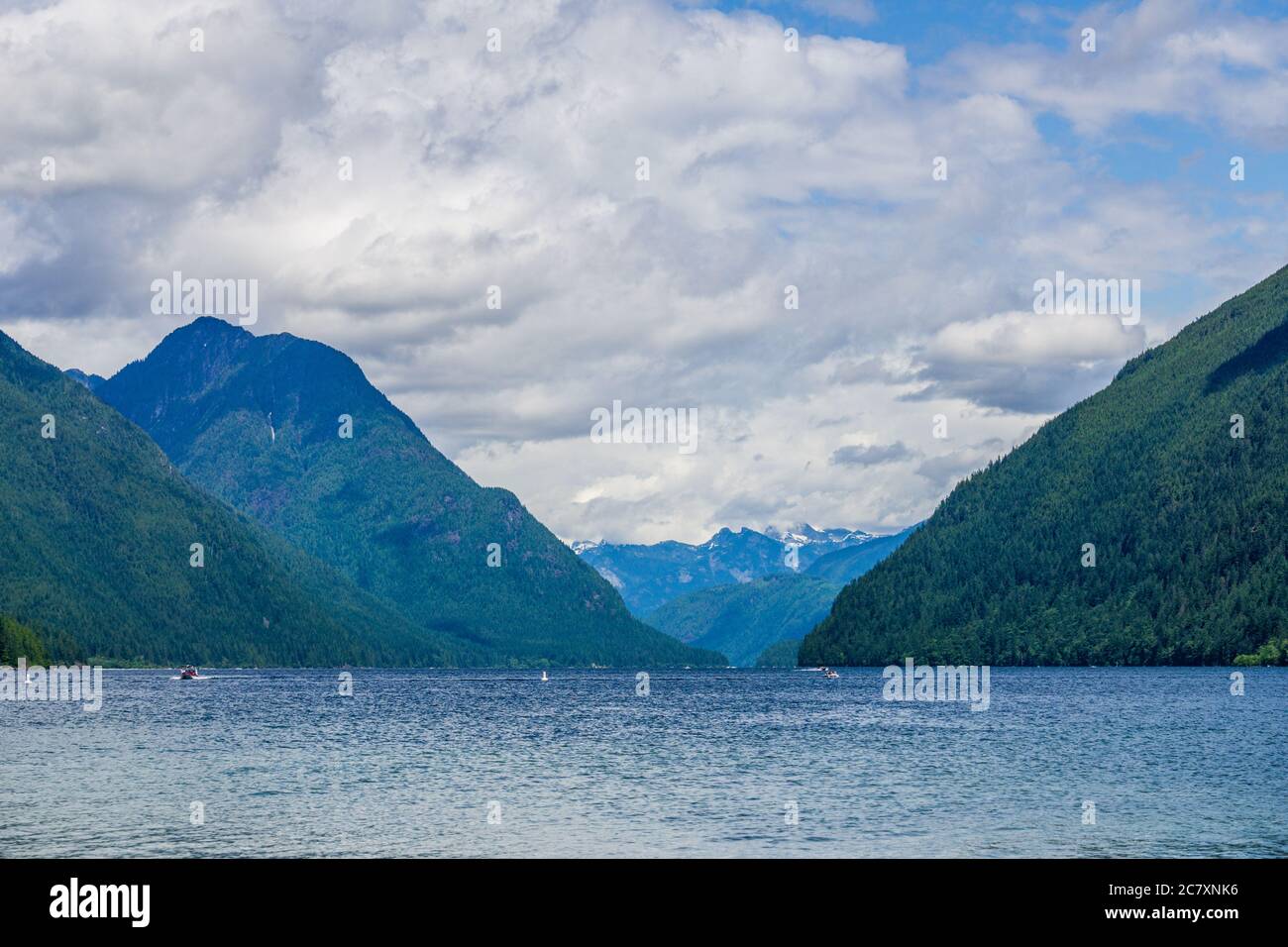 Blauer Bergsee mit grünen Bergen blauer Himmel und weiße Wolken Stockfoto