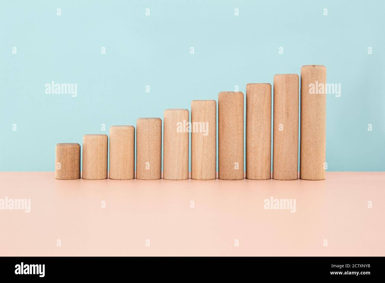 Holzblöcke als zunehmende Graph bar, Infografik Diagramm, Diagramm auf Holztisch über blauem Hintergrund mit Kopierraum Stockfoto