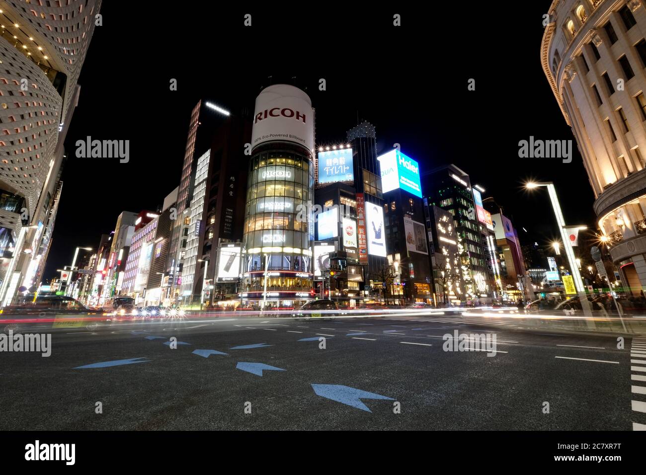 Autos, die bei Nacht an der Kreuzung bei Ginza vorbeifahren. Beliebtes gehobenes Einkaufsviertel von Tokio. Stockfoto