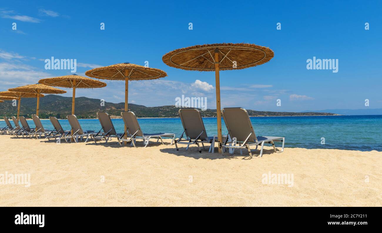 Liegen mit Schirm mit blauem Himmel am tropischen Strand Stockfoto