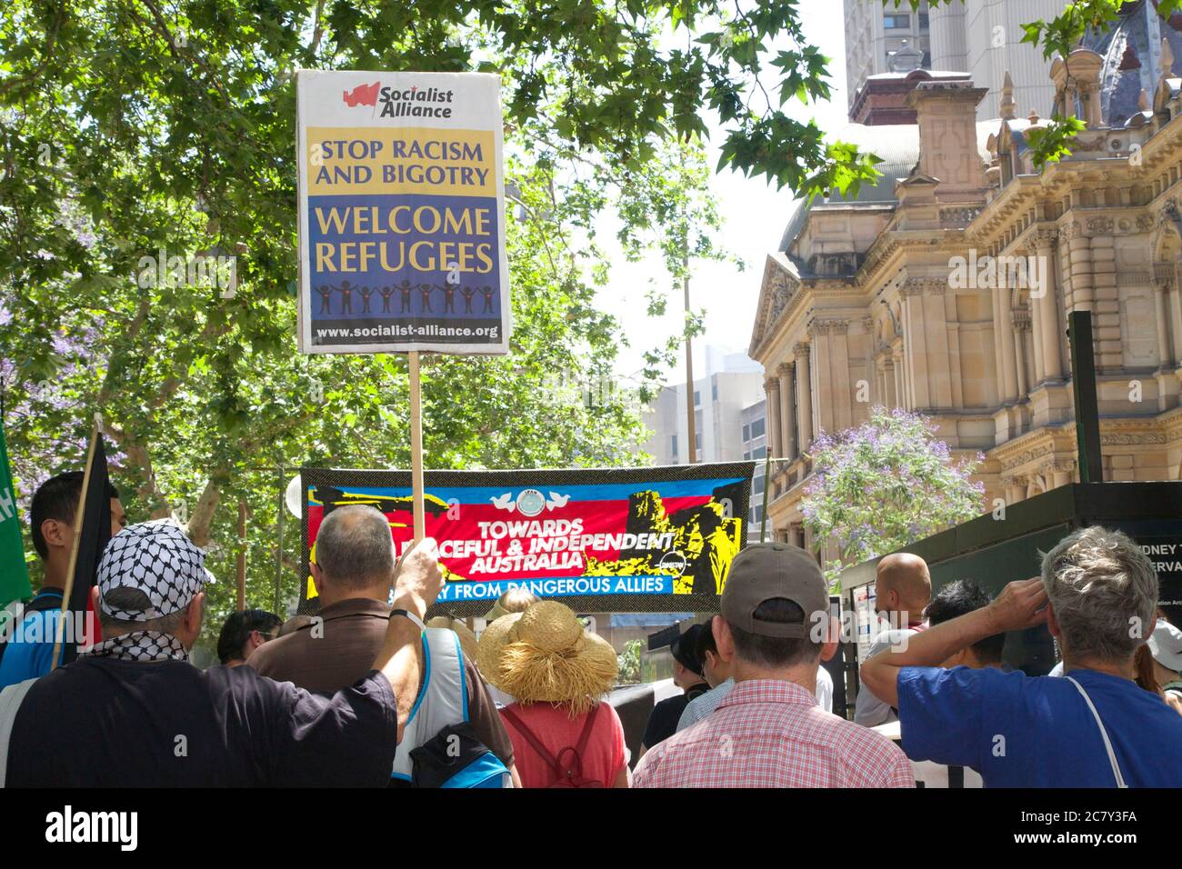 Ein Protestler hält ein Sozialistisches Bündnis Zeichen, das sagt, ‘Stop Rassismus und Bigotterie. Willkommen Flüchtlinge bei einer Kundgebung in Sydney gegen den Krieg im Irak und in Syrien. Stockfoto
