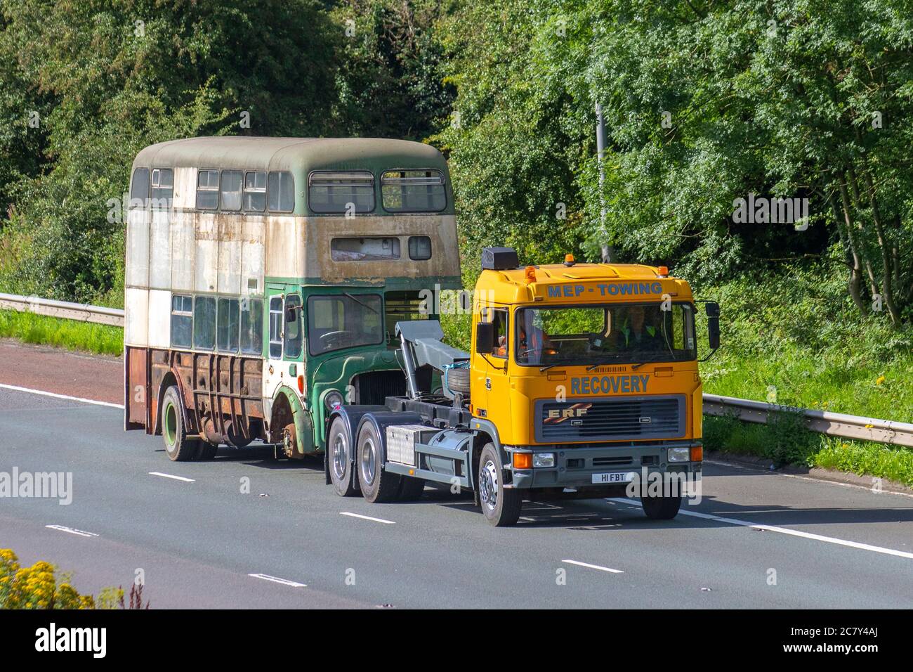 MEP Recovery 1967 60s Leyland Titan Bus (Frontmotor-Doppeldecker mit 1993 ERF-Schlepper, zur Restaurierung abgeschleppt. Der Zustand des Fahrzeugverkehrs in Großbritannien ist heruntergekommen, seltener Sammeltransport im klassischen Oldtimer auf dem Schlepp, verrostete alte Busse, Doppeldecker-Klassiker in nördlicher Richtung auf der Autobahn M6. Stockfoto