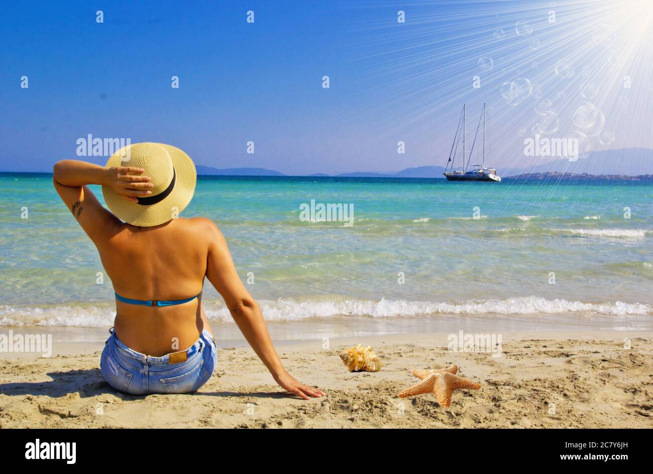 Schöne junge Frau am Strand mit Sonnenschein Stockfoto