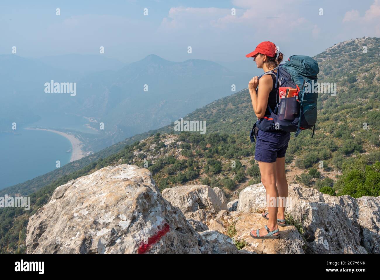 Junge Frau genießt den Blick auf die Blaue Lagune in Oludeniz, Türkei. Wandern auf dem Lykischen Weg Wanderweg in der Region Antalya Stockfoto
