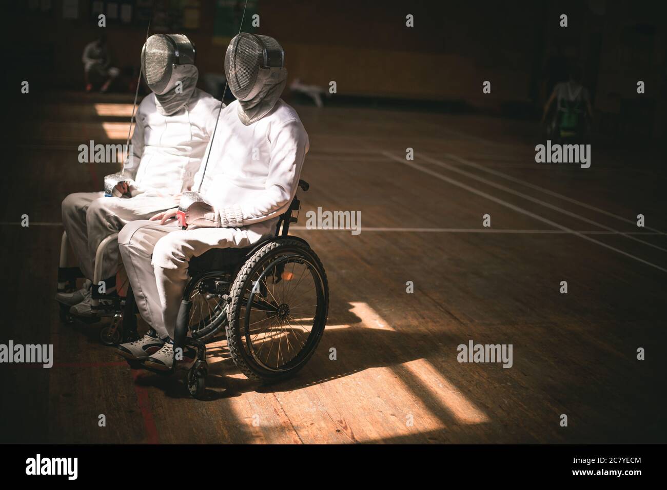Männlicher Fechter im Rollstuhl mit Sicherheitsmaske eines Gesichts, Greifvoppler haltend Stockfoto