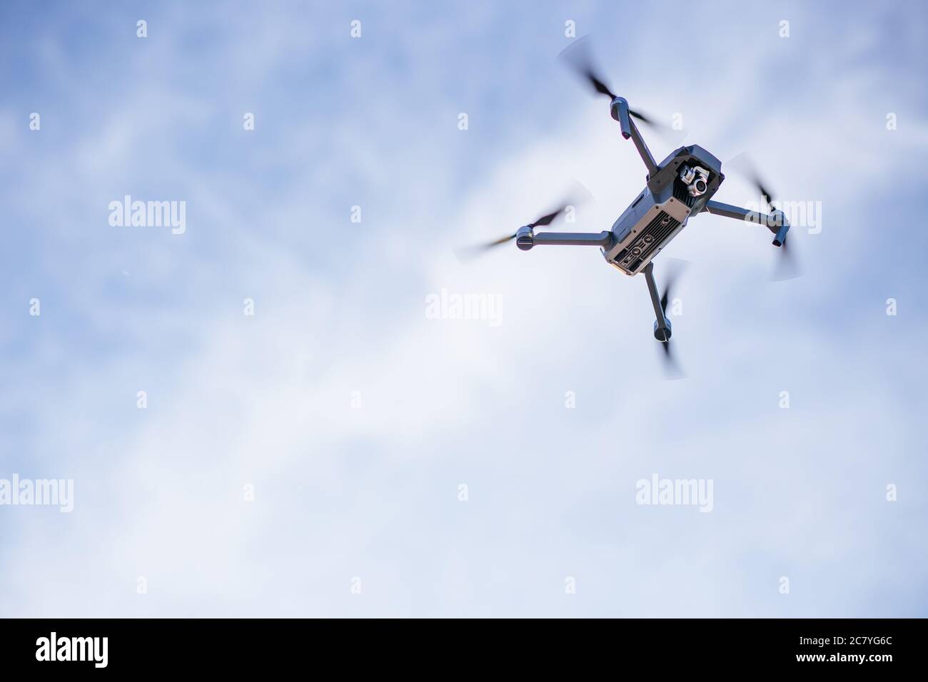 Moderner Drone Quadcopter mit Kamera fliegen auf klaren sonnigen Himmel Sonnenuntergang Hintergrund Stockfoto