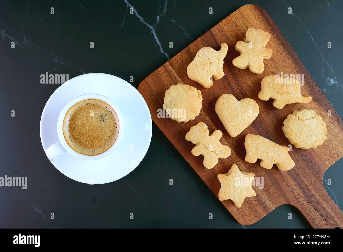 Liebenswert hausgemachte Tier und Herz geformt Plätzchen mit einer Tasse Kaffee auf schwarzem Tisch Stockfoto