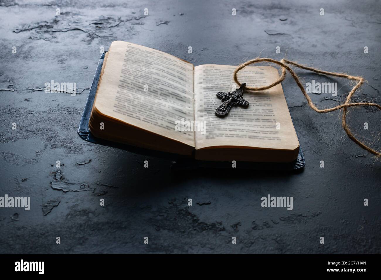 Bibel und Kreuz auf schwarzem Hintergrund Stockfoto