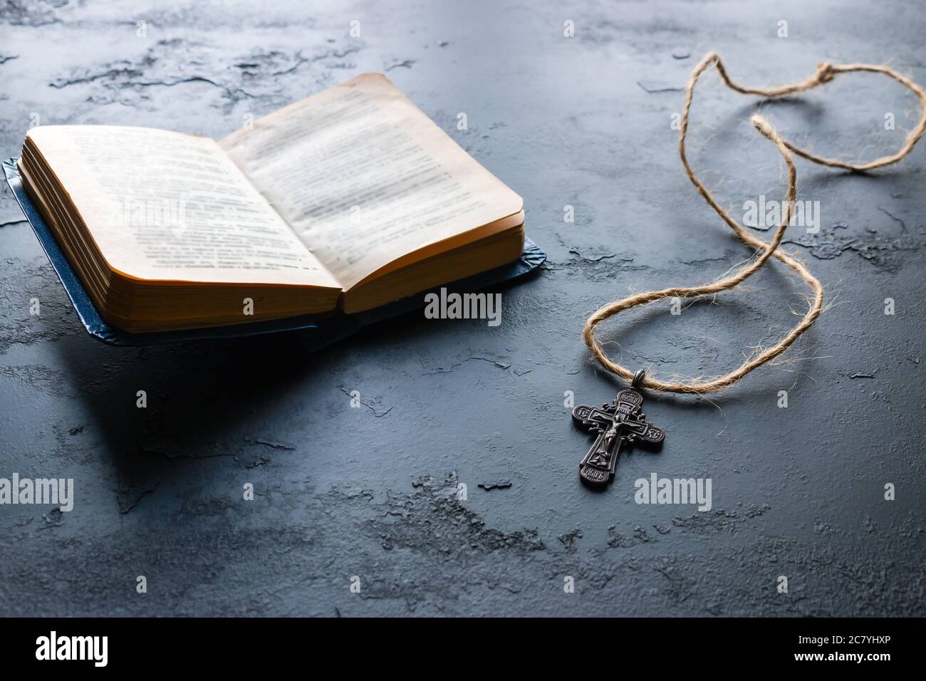 Bibel und Kreuz auf schwarzem Hintergrund Nahaufnahme Stockfoto
