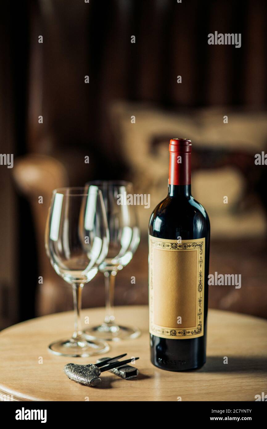 Rotwein-Flasche und Weinglas auf Wodden Tisch Stockfoto