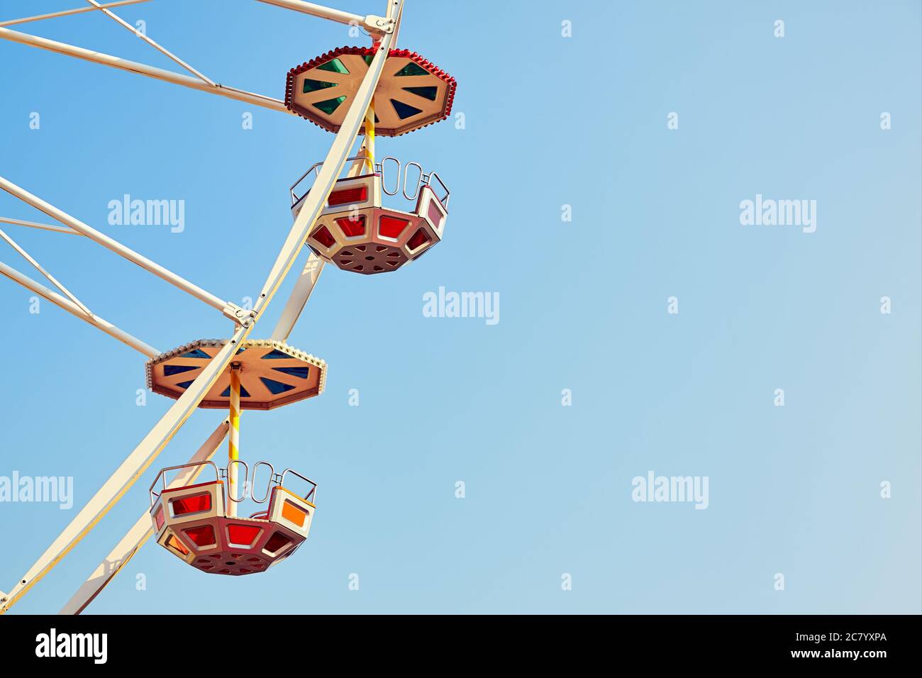 Retro getönte Nahaufnahme Bild von zwei Riesenrad Autos mit wolkenlosem Himmel, Platz für Text. Stockfoto