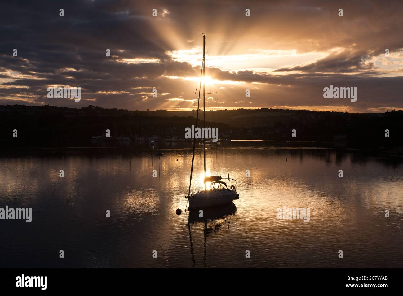 Kinsale, Cork, Irland. Juli 2020. Sonne bricht durch die Wolken, die ein Segelboot im Hafen von Kinsale, Co. Cork, Irland, umhüllt. - Credit David Creedon / Alamy Live News Stockfoto