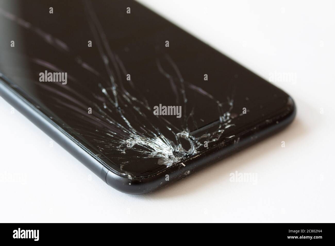Ecke des Mobiltelefons mit defekter Anzeige nach dem Ablegen. Abgestürzt schwarzen Smartphone Nahaufnahme. P erblicktes Bild auf weißem Hintergrund. Stockfoto