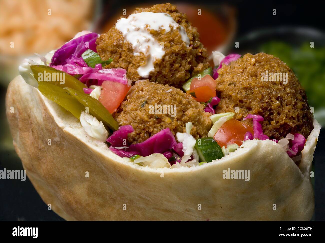 Falafel in Pita Brot mit Salat und Tahini Sauce. Gebratene Patty-Kugeln aus gewürzten Kichererbsen. Falafel ist eine beliebte Form der Fast Food in der Midd Stockfoto