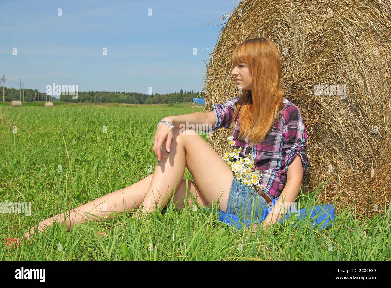 Schöne Frau in einem Feld mit Heuballen Stockfoto