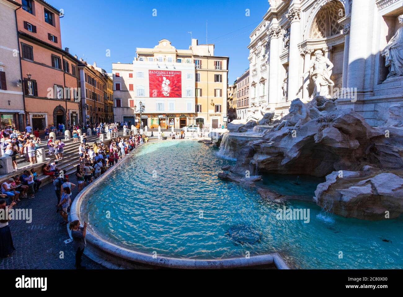 Blick von oben auf die Menschen am Trevi-Brunnen. Vor dem Palazzo Poli, entworfen von Nicola Salvi, ist er der größte Barockbrunnen Roms. Stockfoto