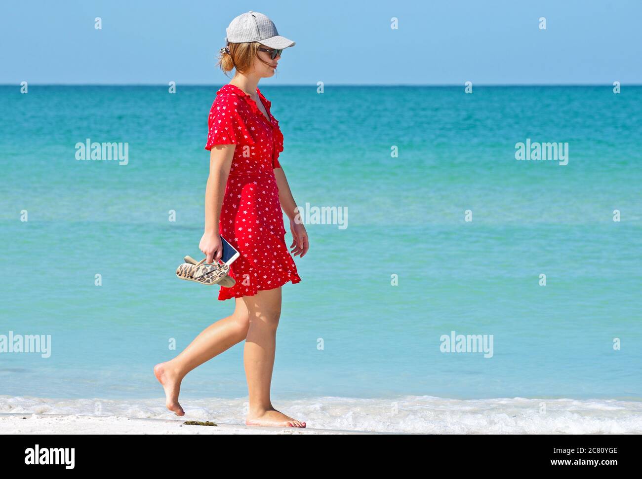 HOLMES BEACH, ANNA MARIA ISLAND, FL / USA - 1. Mai 2018: Ypong-Frau bei einem Spaziergang am Strand und einem schönen Sommertag. Stockfoto