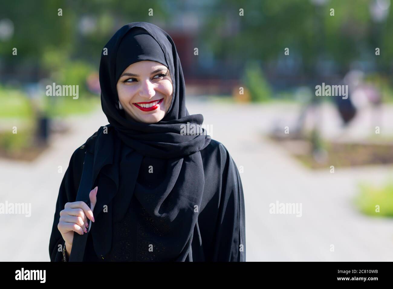 Eine glückliche muslimische Frau in orientalischer Kleidung spaziert. Stockfoto