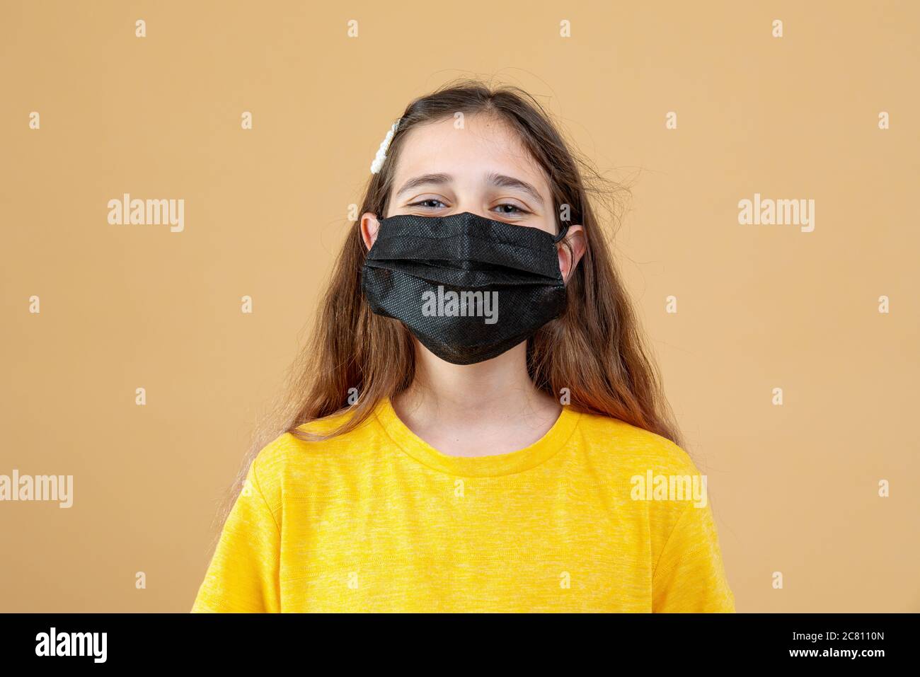 Maskiertes Kind - Schutz gegen Influenza-Virus. Kleine kaukasische Mädchen mit Maske für pm2.5 schützen. Biologische Waffen. Baby auf einer Orange Stockfoto