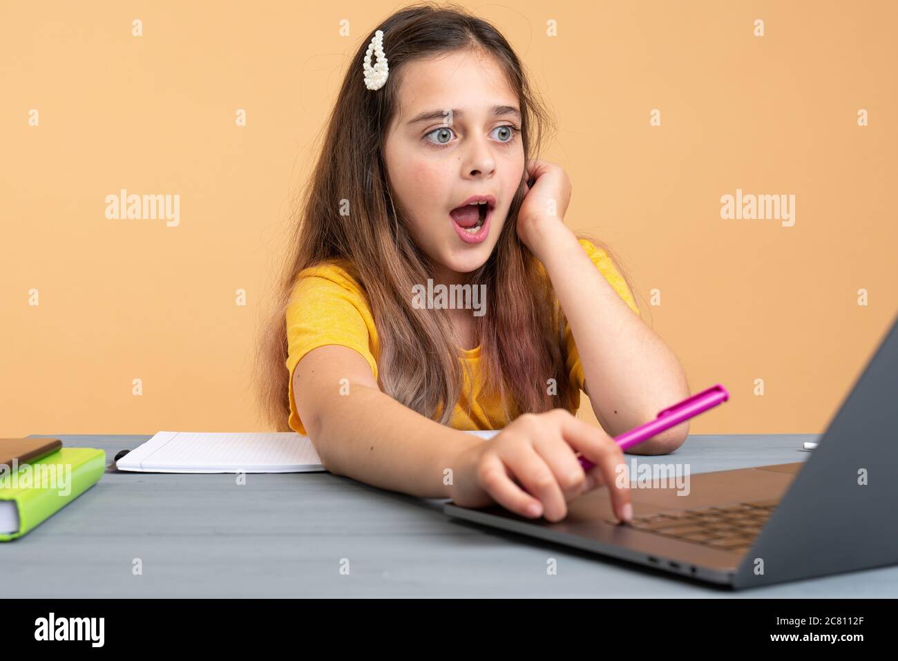 Brunette attraktive Mädchen suchen mit Erstaunen auf Laptop Stockfoto