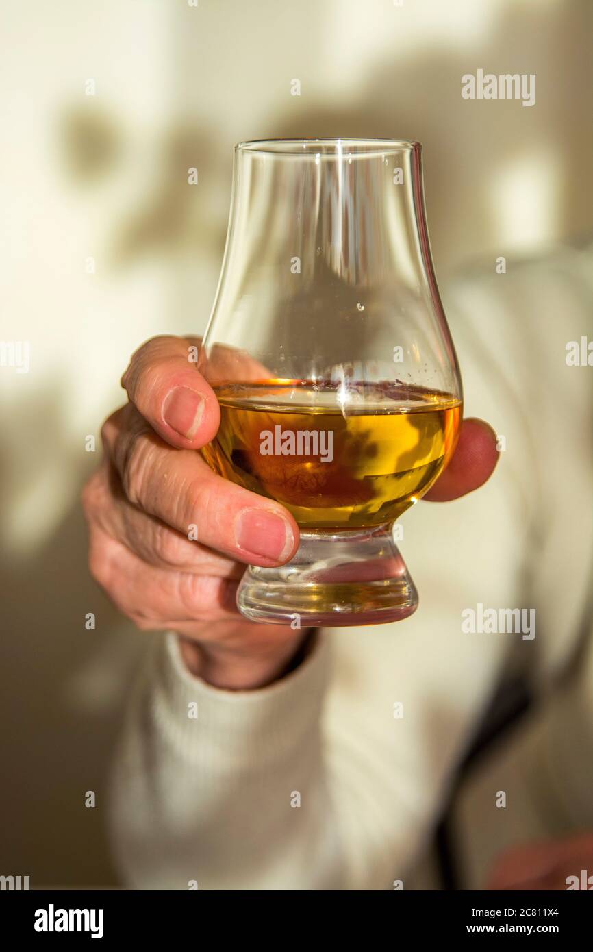 Frau Hand hält Glas Whisky Stockfoto