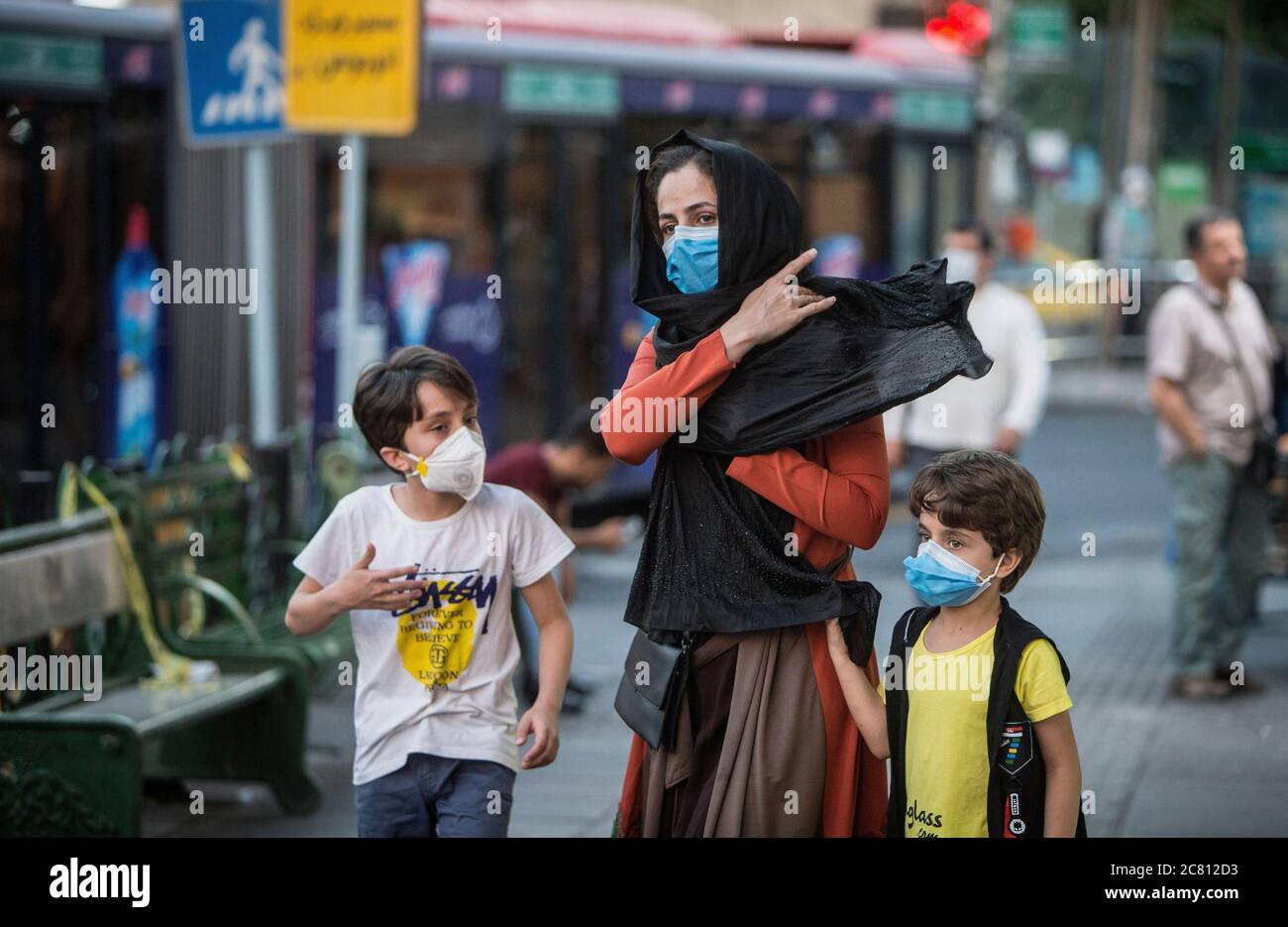 Teheran, Iran. Juli 2020. Kinder mit Gesichtsmasken gehen am 19. Juli 2020 mit ihrer Mutter auf einer Straße in Teheran, Iran. Laut dem staatlichen Fernsehen sind die bestätigten neuen Coronavirus-Fälle im Iran am Montag auf 276,202 gestiegen, nachdem über Nacht 2,414 neue Infektionen registriert wurden. Quelle: Ahmad Halabisaz/Xinhua/Alamy Live News Stockfoto