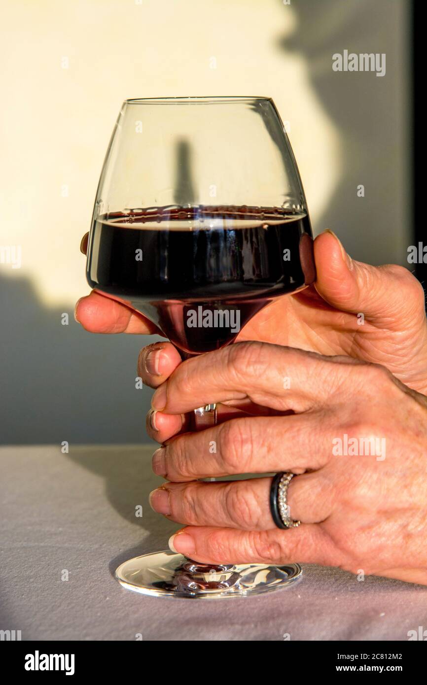 Frau Hand hält ein Glas Rotwein Stockfoto