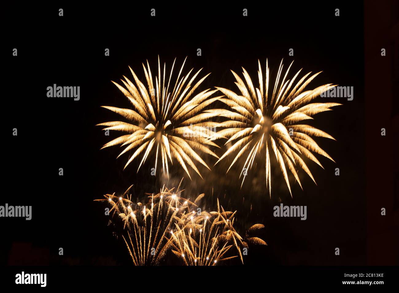 Farbenfrohe Feuerwerke erleuchten den Nachthimmel während einer festlichen Feier in einer urbanen Umgebung Stockfoto