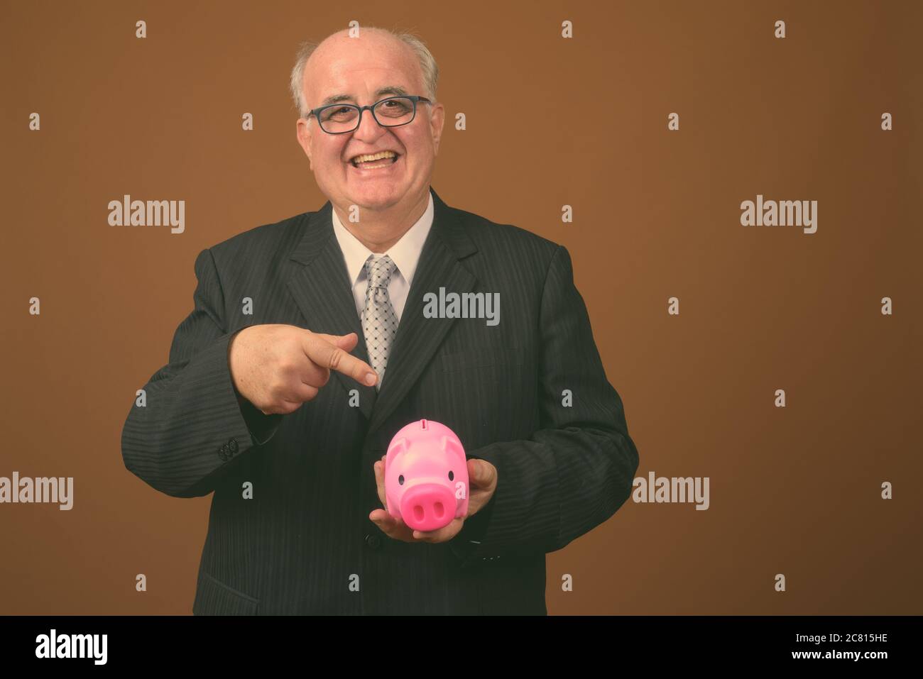 Übergewichtiger Geschäftsmann mit Brillen vor braunem Hintergrund Stockfoto