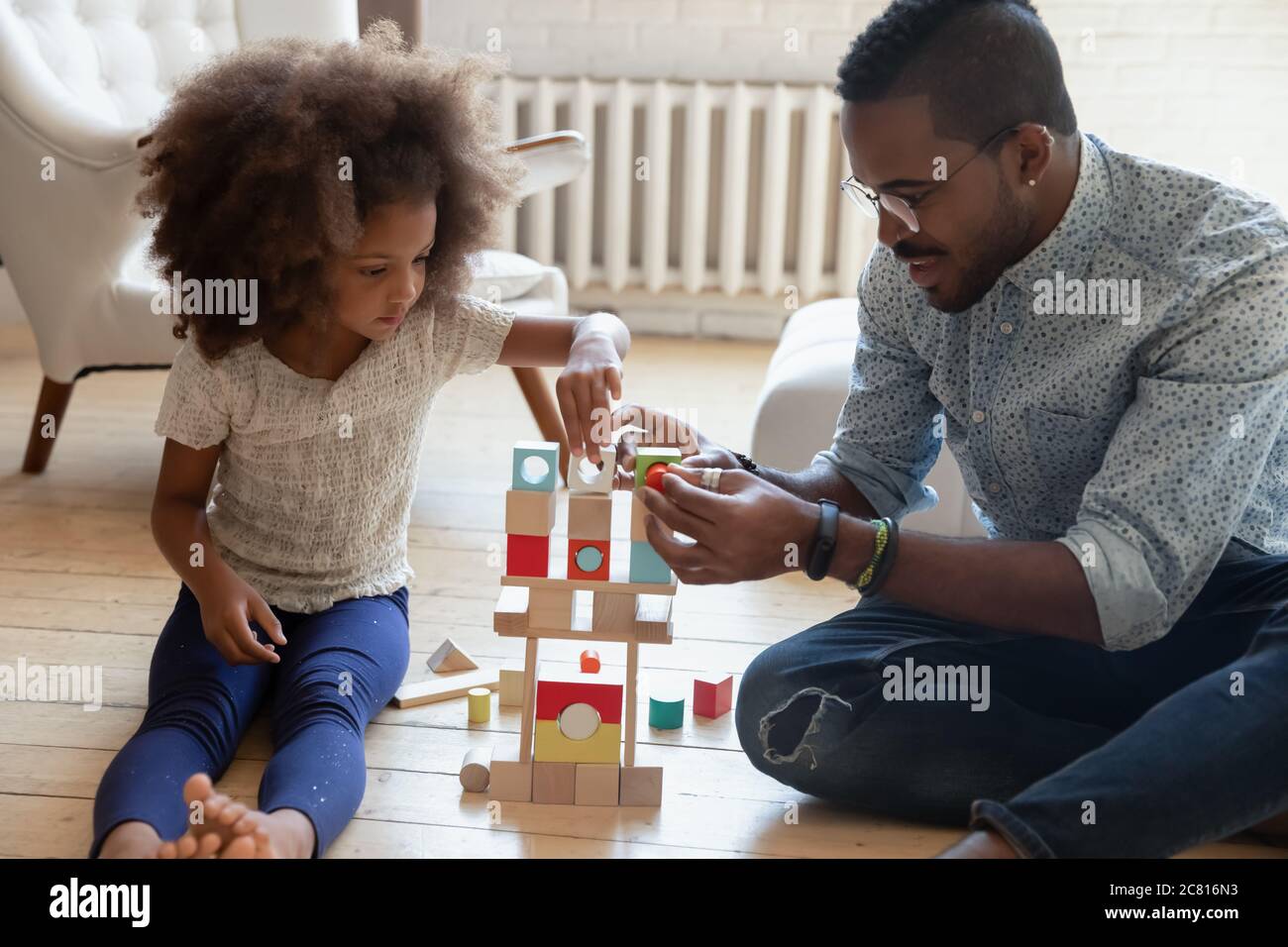 Liebevolle biracial Papa spielen Blöcke mit kleinen Tochter Stockfoto