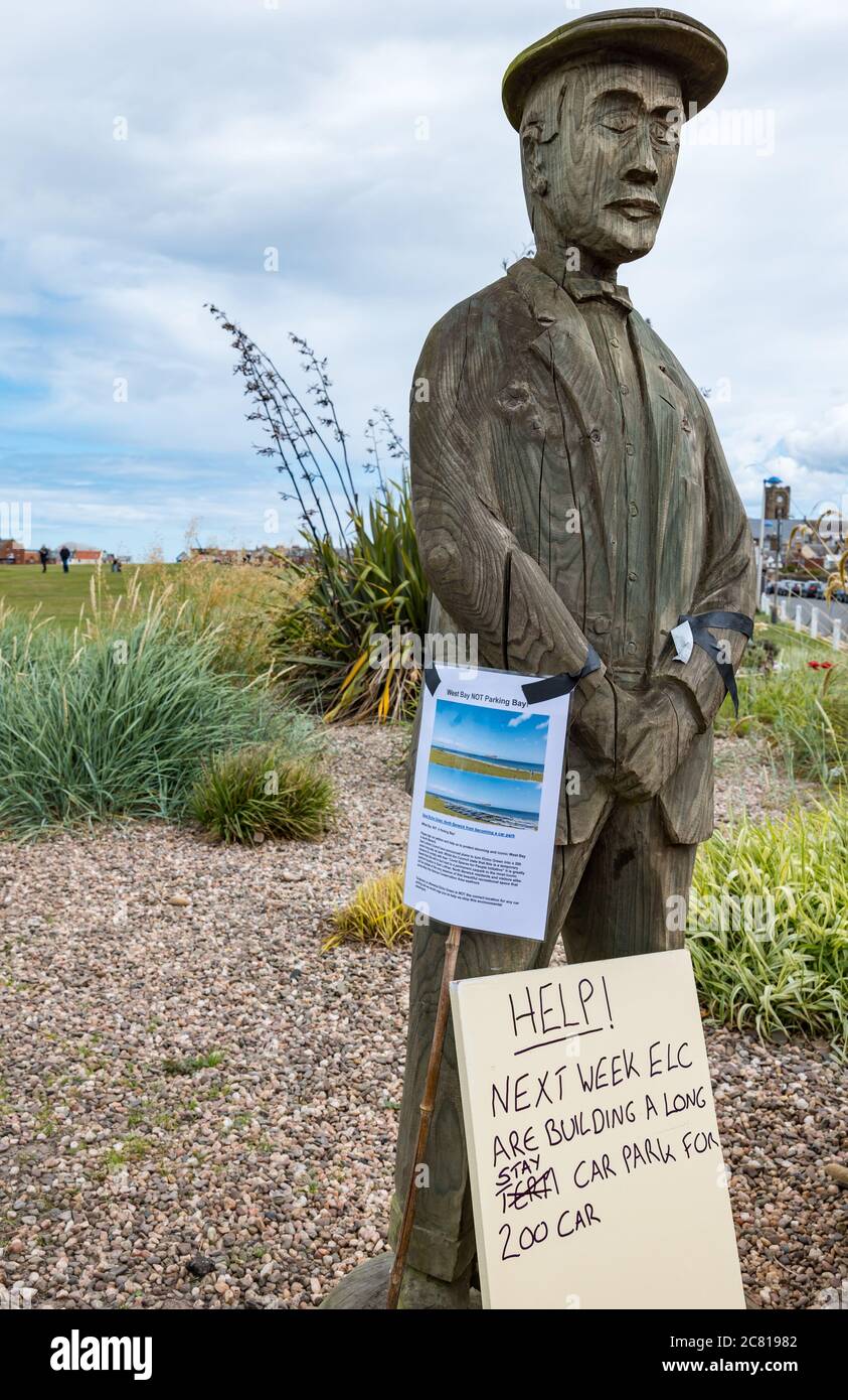 North Berwick, East Lothian, Schottland, Großbritannien, 20. Juli 2020. Kampagne gegen Covid-19-Parkplatzplan: East Lothian Council schlägt einen temporären 200-Langzeitparkplatz am berühmten Elcho Green, West Beach; Teil von "Maßnahmen für Menschen", um Menschen zu helfen, sich während der Coronavirus-Pandemie sozial zu distanzieren und Händler für den Verlust von Parkplätzen zu kompensieren, die bereits in der High Street entfernt wurden. Eine Online-Petition 'West Bay Not a Parking Bay', um gegen die Zerstörung des Schönheitsflecks zu widersprechen, hat fast 4,000 Unterschriften gesammelt. Ein Hinweis auf der Holzstatue von Ben Sayers, Golfer aus dem 19. Jahrhundert Stockfoto