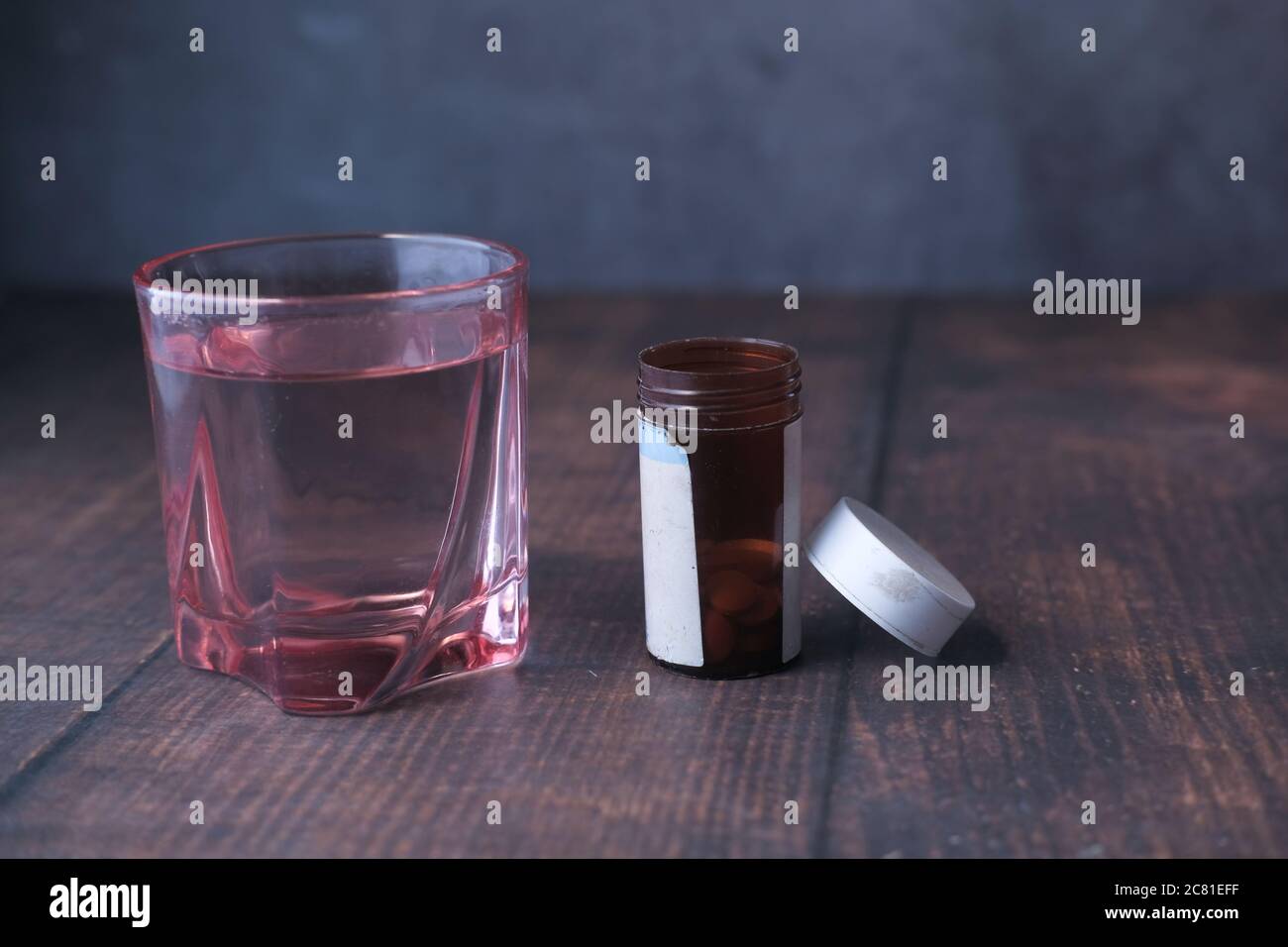 Nahaufnahme der Pille contianer und Glas Wasser auf dem Tisch Stockfoto