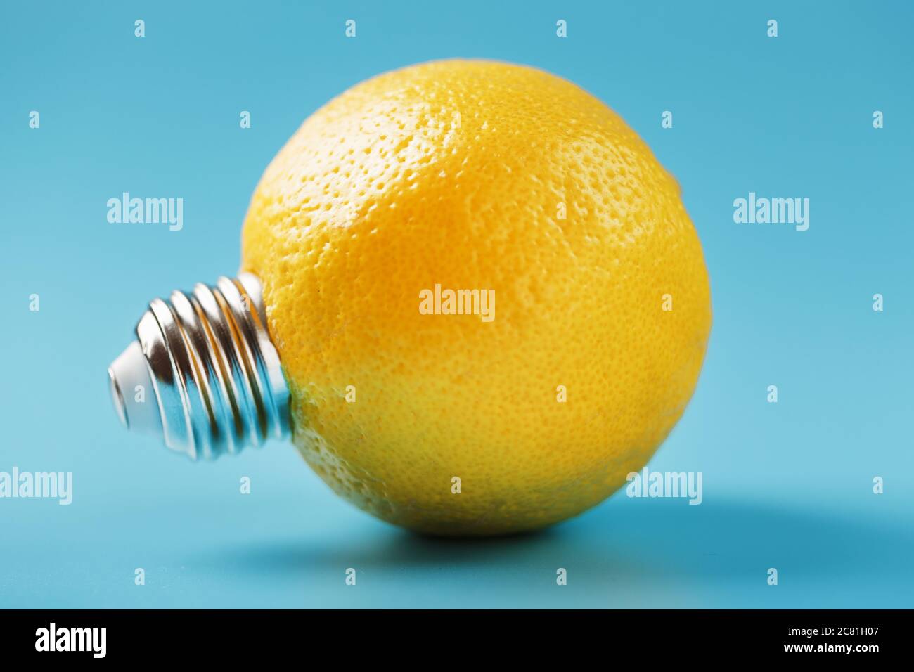 Zitronenfrucht als Glühbirne auf blauem Hintergrund. Die konzeptionelle Idee. Stockfoto