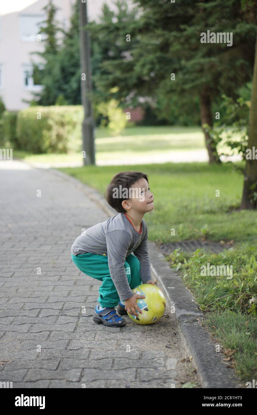 POSEN, POLEN - 13. Jul 2017: Drei Jahre altes Kind spielt mit einem Ball auf einer Straße in der Stadt Stockfoto