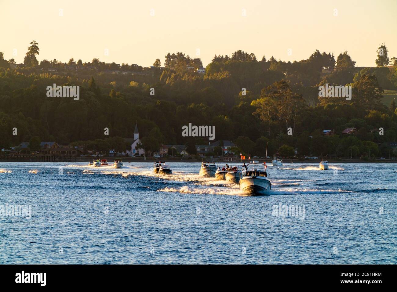 Beeindruckende Aussicht auf den See Llanquihue mit Motorbooten, die bei Sonnenuntergang segeln. Frutilllar, Lake District Stockfoto