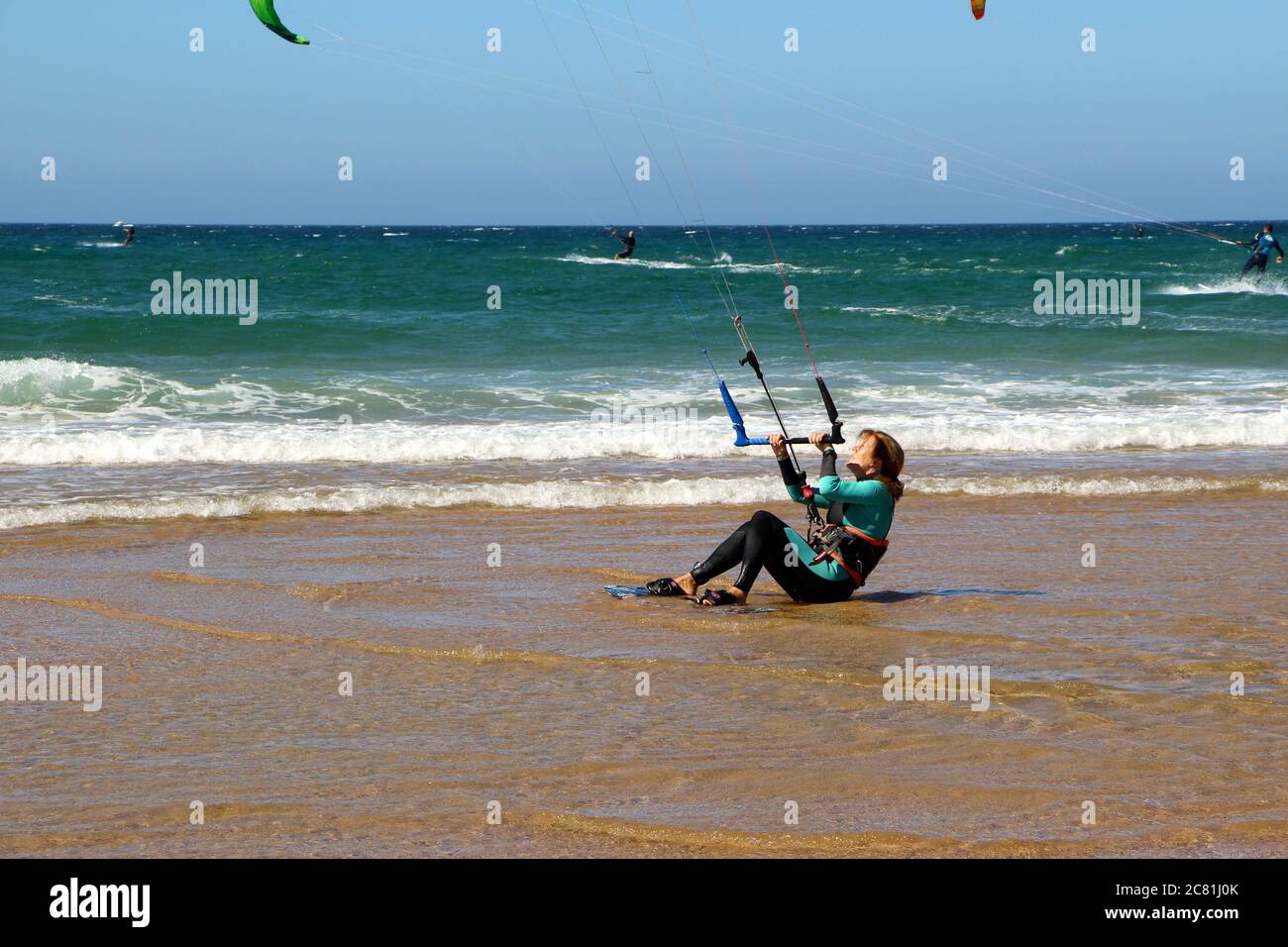 Kitesurferin oder Kiteboarderin bereitet sich auf Kitesurfen vom Strand von Somo an einem sonnigen, windigen Nachmittag vor Santander Cantabria Spanien Sommer Stockfoto