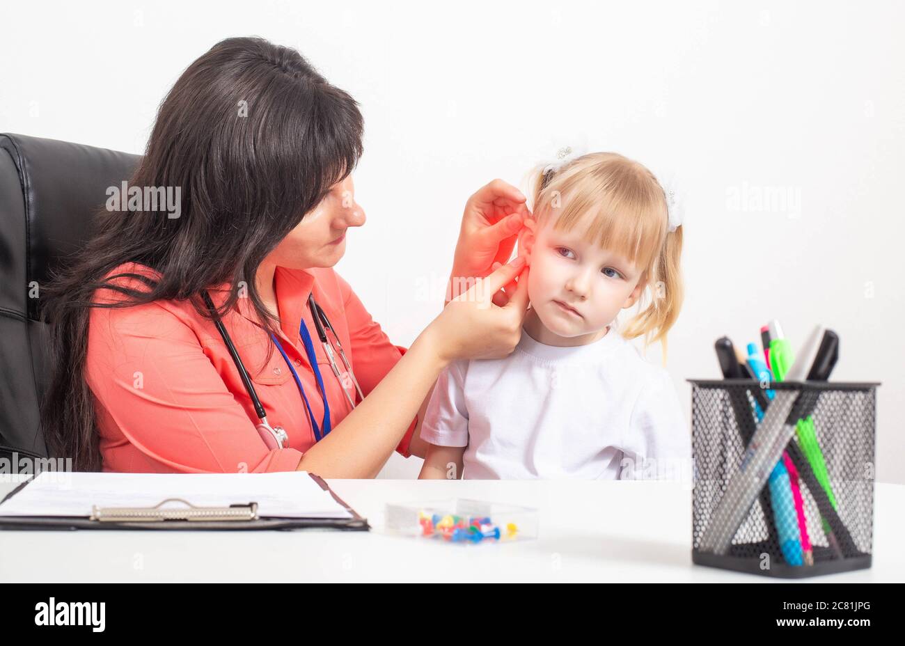 Doktor otolaryngologe untersucht das Ohr eines kleinen Mädchens, das Schmerzen im Ohr hat. Das Konzept der Otitis media und Entzündung des Trommelfells, therap Stockfoto