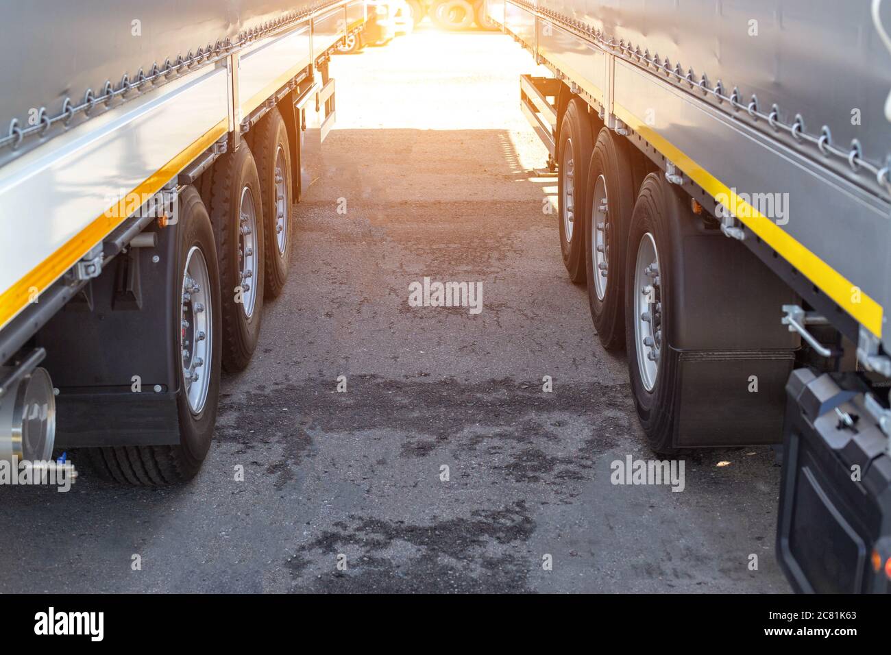 Zwei neue LKW-Sattelauflieger werden in einem Lkw-Stopp abgestellt. Cargo Transport Konzept Achslast, Überlast, Copy Space for Text Stockfoto