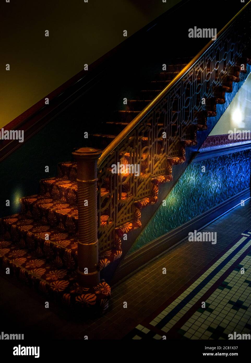 Bunte Flare Beleuchtung im alten Gebäude mit Treppe und Zinn geprägte Vertäfelung mit Mosaikfliesen Boden in geheimnisvoller Atmosphäre, USA Stockfoto