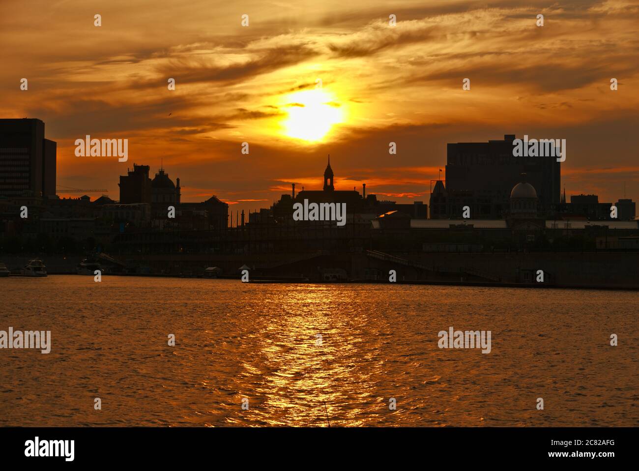 Skyline von Montreal Old Port bei Sonnenuntergang. Im Vordergrund ist der Fluss Saint Laurent. Stockfoto