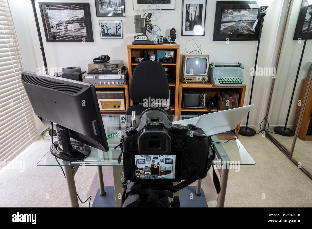 Home Office vlogging Studio mit Vintage-Elektronik auf Regalen. Wandkunst ist das Werk des Fotografen. Stockfoto