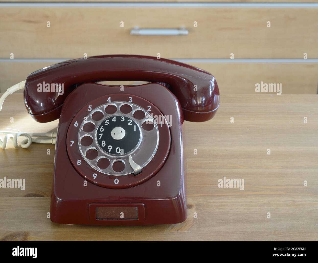 burgundy Vintage traditionelle Telefon auf einem Holztisch Stockfoto