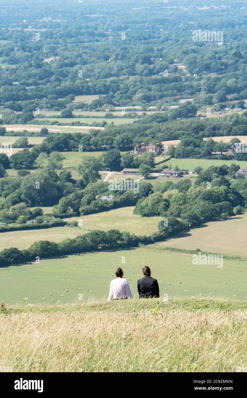 Junges Paar auf einem Hügel, das den Blick über das Devil's Deich Valley, South Downs, Sussex, Großbritannien, bewundert Stockfoto