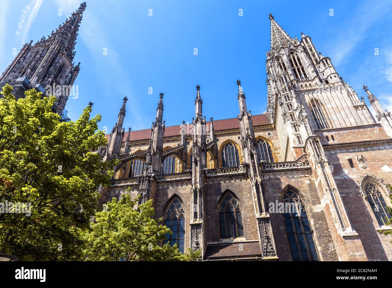 Münster oder Dom von Ulm, Deutschland. Es ist das Wahrzeichen von Ulm. Verzierte Fassade der alten gotischen Kirche gegen den Himmel im Sommer. Blick auf das berühmte med Stockfoto