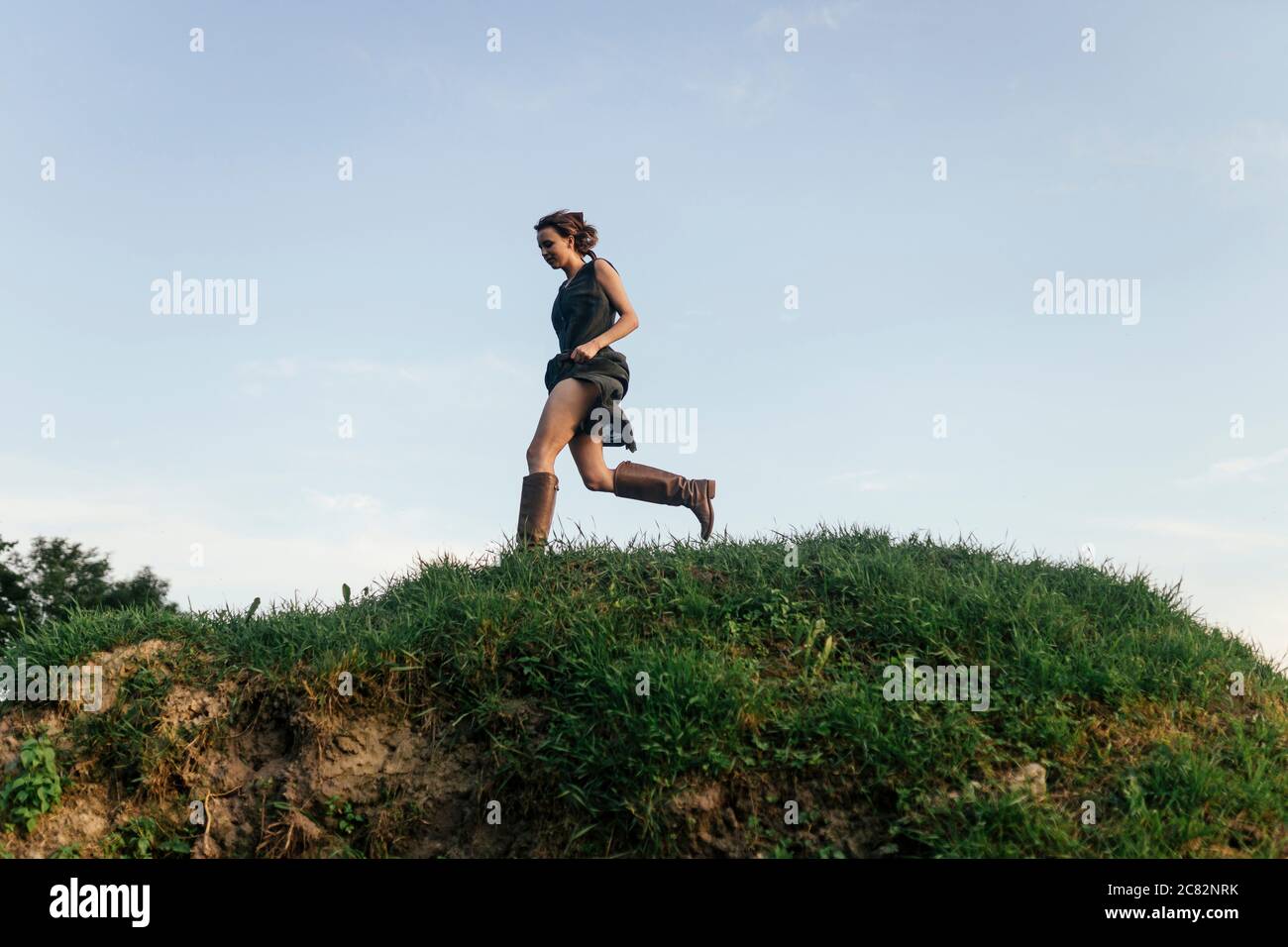 Die Frau rennt den Hügel hinunter Stockfoto