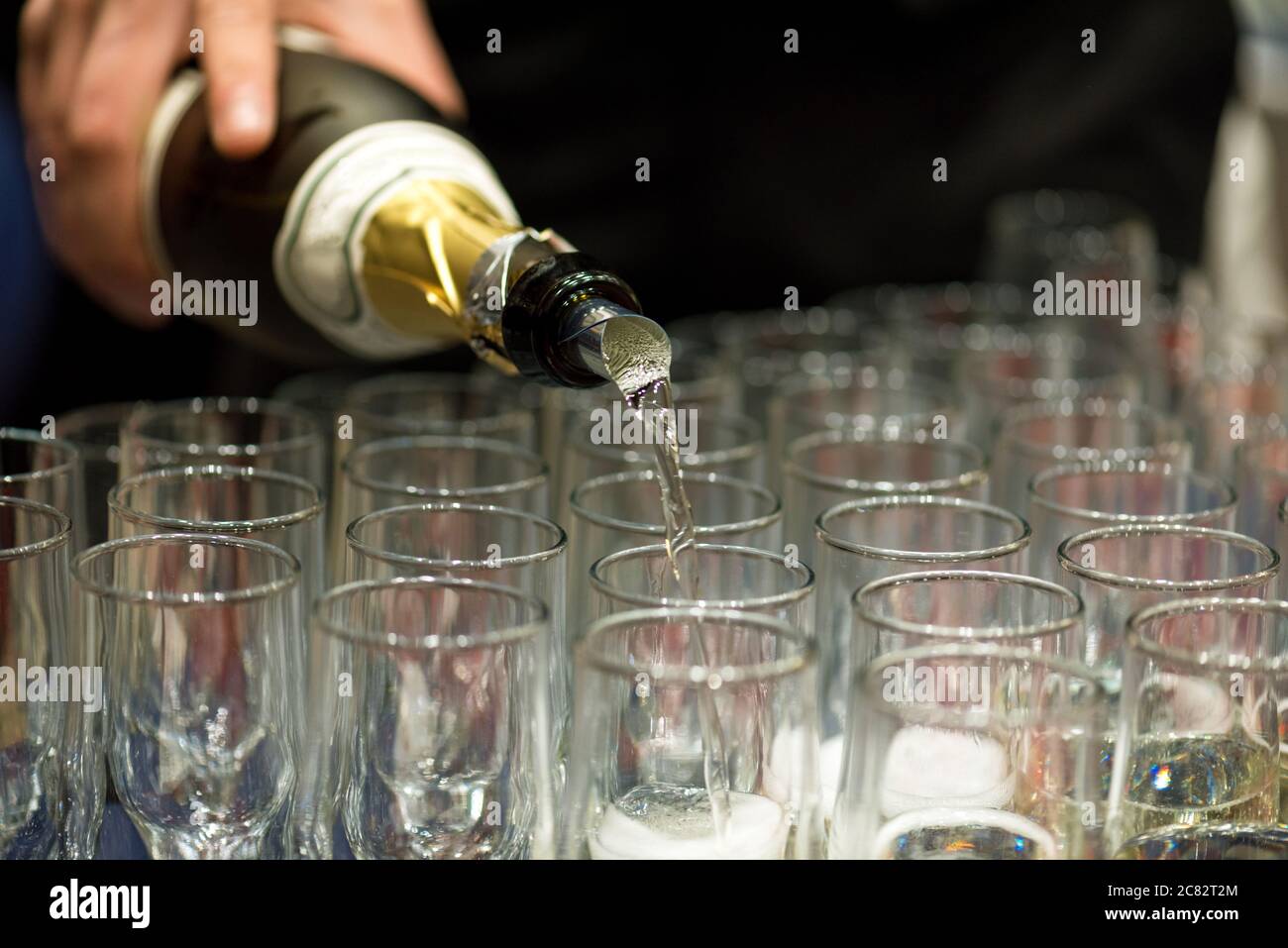 Barkeeper in Gläser gießen Champagner auf einer Party. Stockfoto