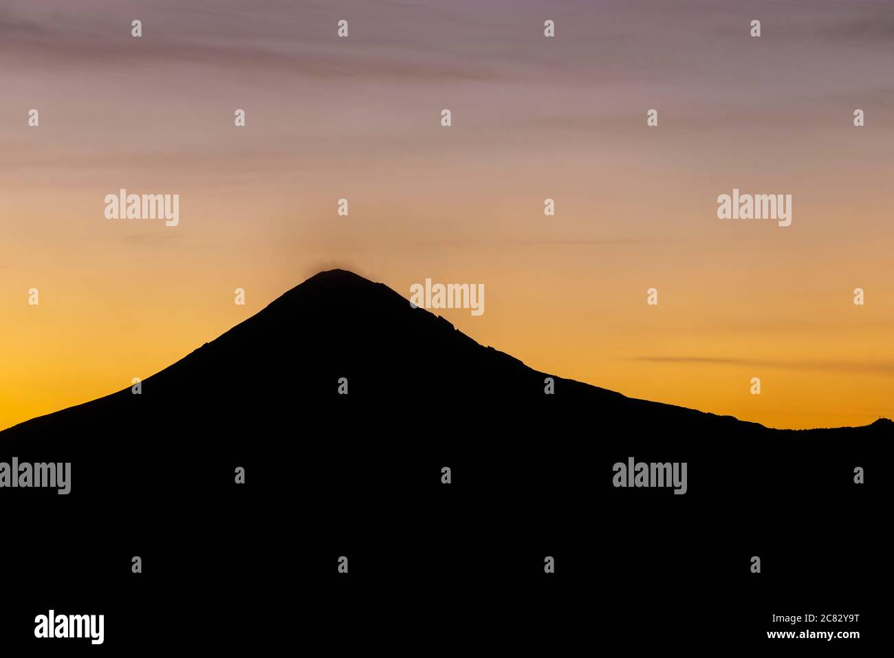 Silhouette des aktiven Vulkans Popocatepetl mit Rauch bei Sonnenuntergang, Puebla, Mexiko. Stockfoto